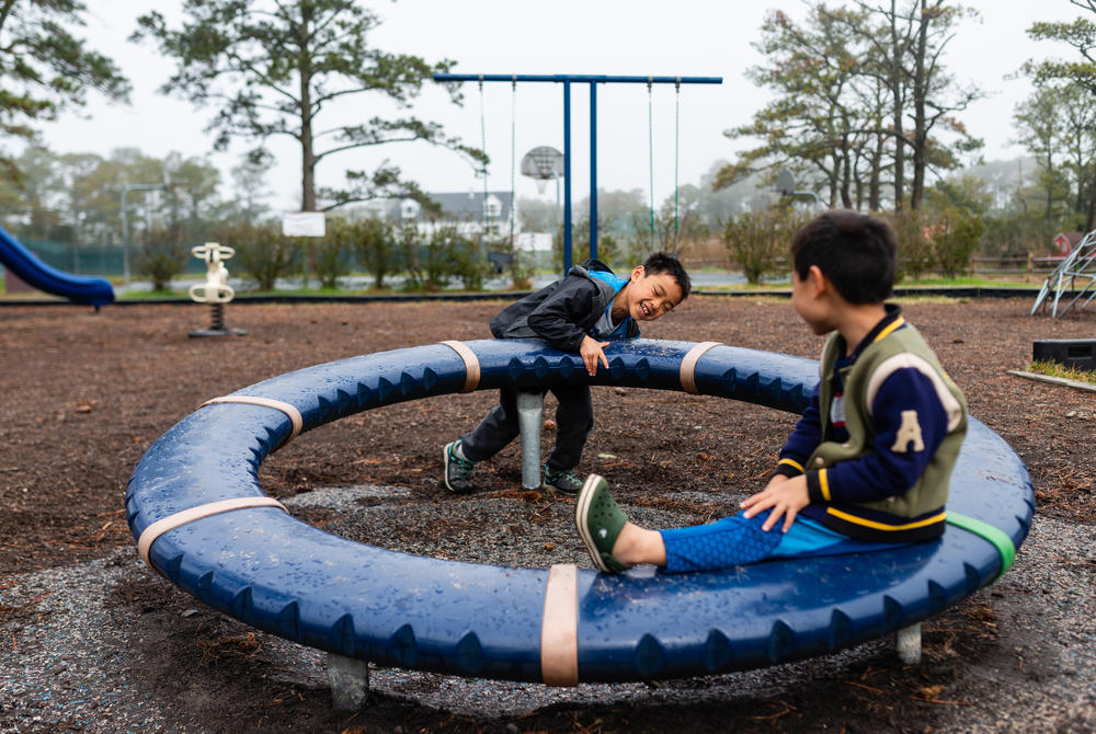 Henry pushes a wheel as Hayle sits on it in a park in Chincoteague, Md., on April 14, 2019.