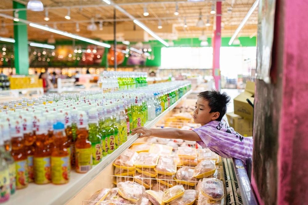 Henry reaches for a strawberry Ramune, a Japanese soda-like drink at a grocery store in Eden Center in Falls Church, Va., on Oct. 12, 2019.