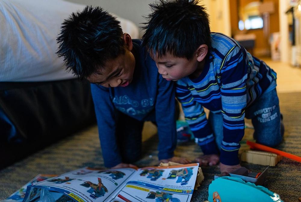 Hayle and Henry look at instructions while attempting to build a Hot Wheels set in Ocean City, Md., on April 14, 2019.