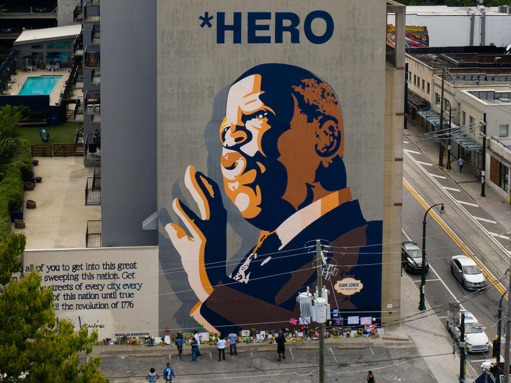Mourners pay their respects at a mural of Rep. John Lewis painted on a building in Atlanta. The civil rights icon and congressman died on Friday.