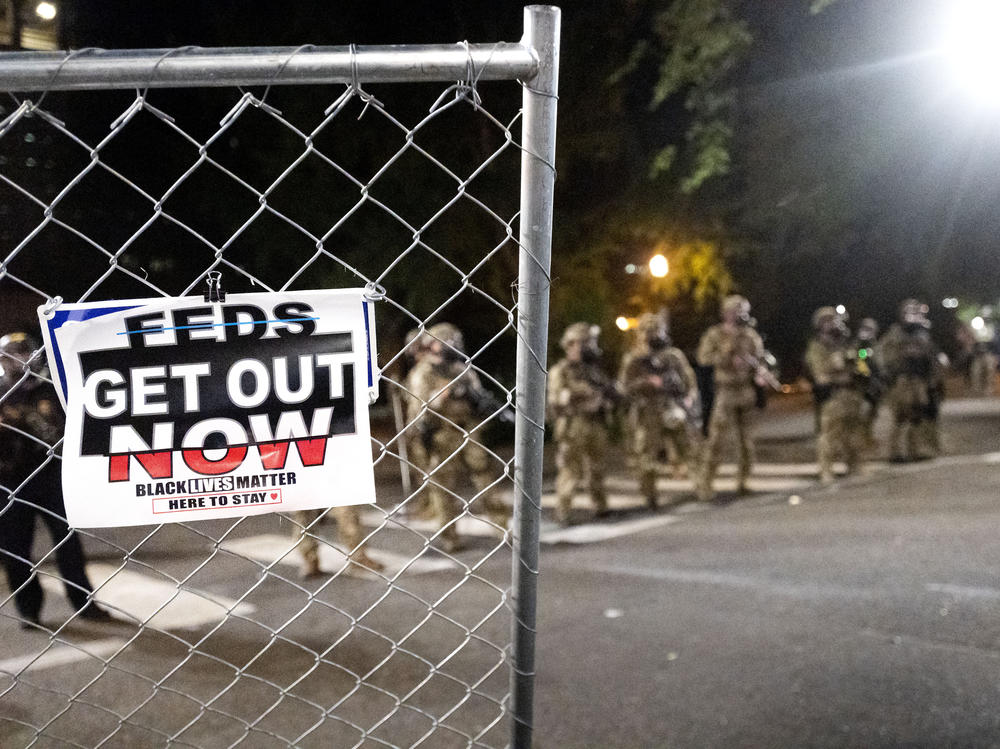 Federal agents disperse protesters near the Mark O. Hatfield U.S. Courthouse on Monday in Portland, Ore. State and local officials say the federal law enforcement officers have incited violence in the city.