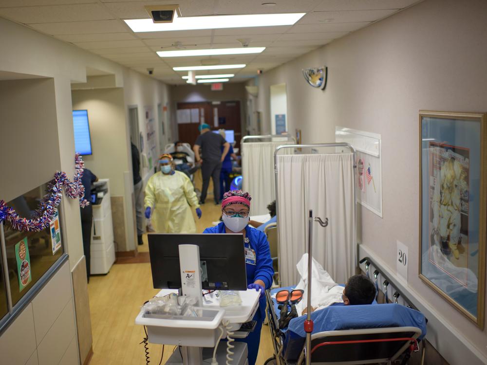 A health care worker talks to a patient in the emergency room at OakBend Medical Center in Richmond, Texas, on July 15.