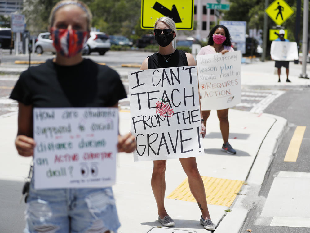 Middle school teacher Brittany Myers (center) stands in protest last week at the Hillsborough County School District Office in Tampa, Fla. Teachers and administrators have rallied against the reopening of Florida schools due to concerns about the coronavirus.