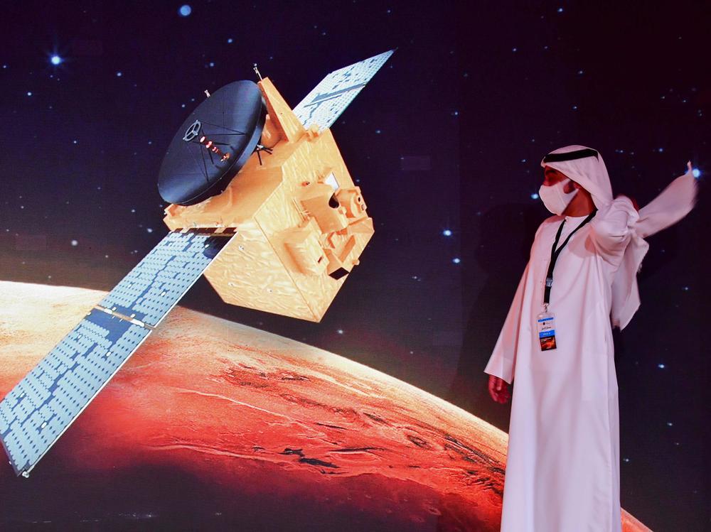 An Emirati walks past a screen displaying the 