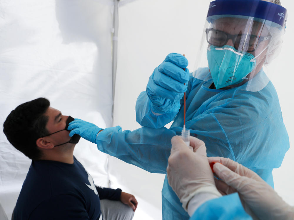 Dr. Glenn Lopez administered a standard test for the coronavirus to Daniel Contreras at a mobile clinic in South Los Angeles last week. Though highly accurate, such tests can take days or more to process.