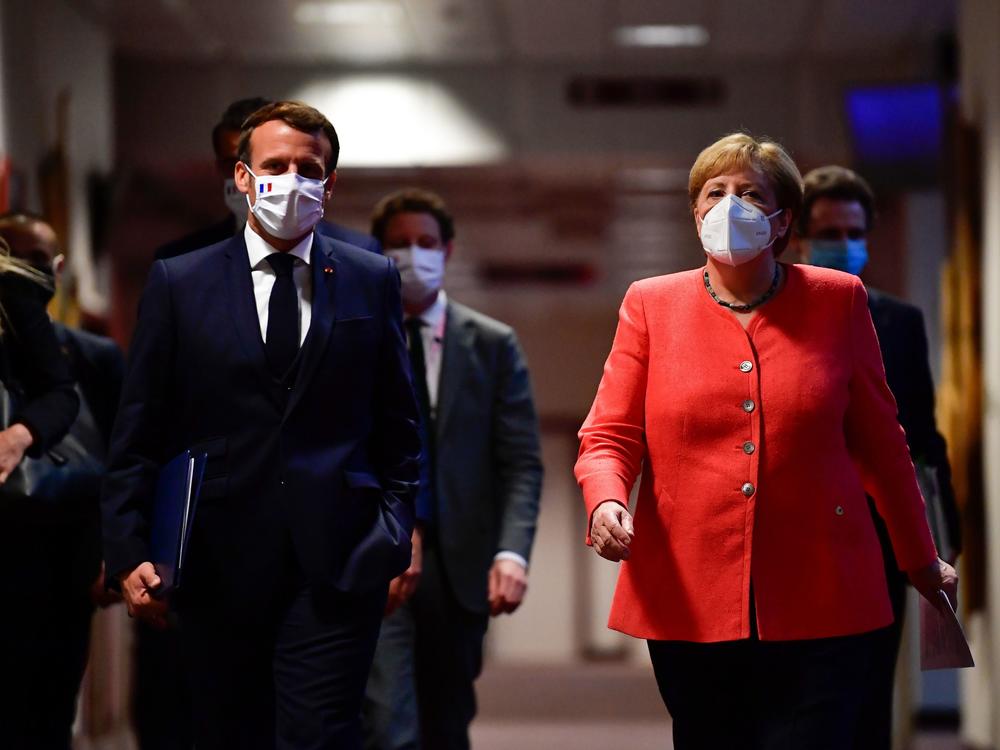 French President Emmanuel Macron and German Chancellor Angela Merkel arrive for a joint news conference at the end of the European summit at EU headquarters in Brussels on Tuesday.