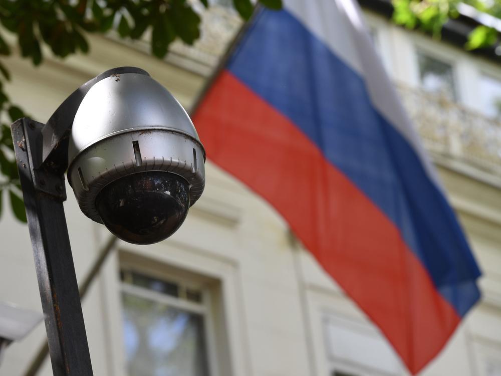 A security camera and flag adorn the entrance to the Russian Embassy in London. On Tuesday, lawmakers slammed the British government for failing to look into possible Russian interference in U.K. politics.