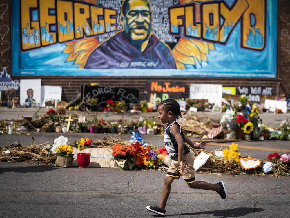 The Minnesota Legislature has approved a bill to revise rules on police use of force in response to the killing of George Floyd. Here, a boy runs past a mural at a memorial to Floyd outside Cup Foods.