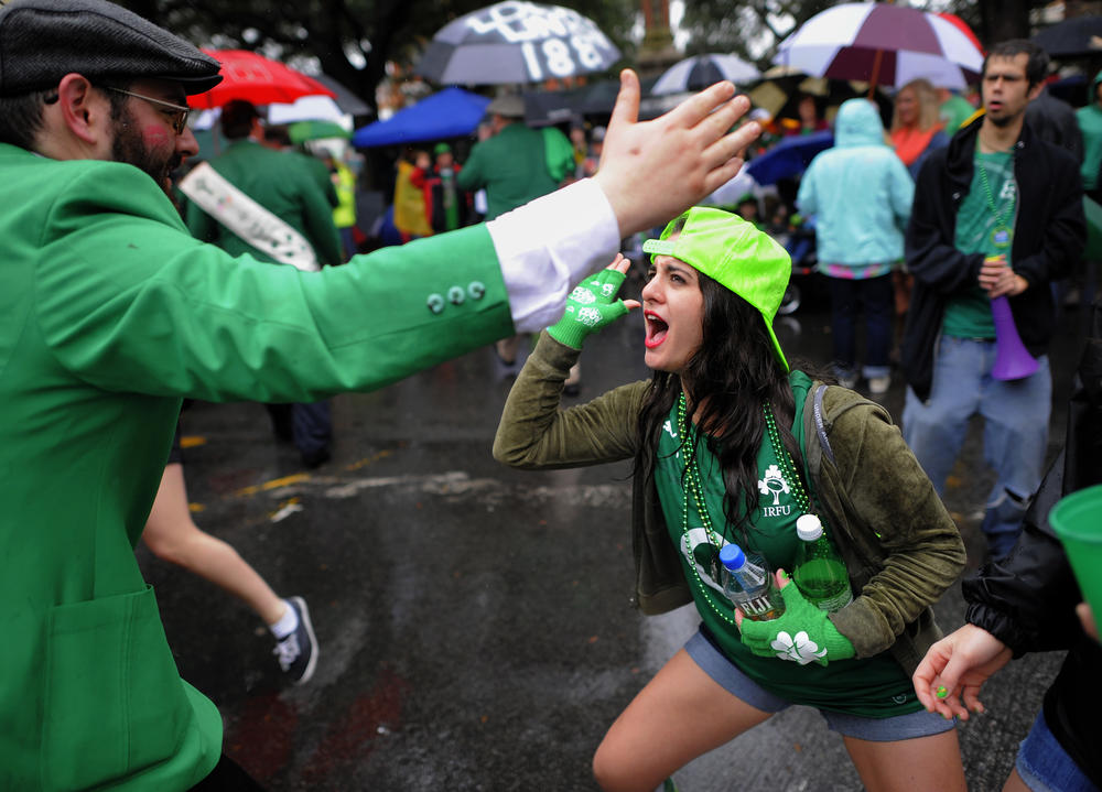 In this March 17, 2014 file photo, Andrea Sicignano of Long Island, N.Y., right, high-fives a participant marching in Savannah's 190-year-old St. Patrick's Day parade in Savannah, Georgia.