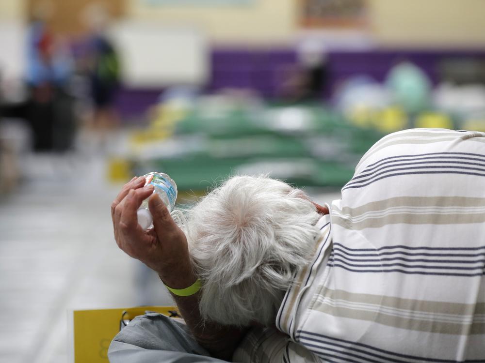 An evacuee lies on a cot at an evacuation shelter for people with disabilities in Stuart, Fla., in preparation for Hurricane Dorian on Sept. 1, 2019. Now, with the pandemic raging, officials across the South are trying to adjust their evacuation and shelter plans.