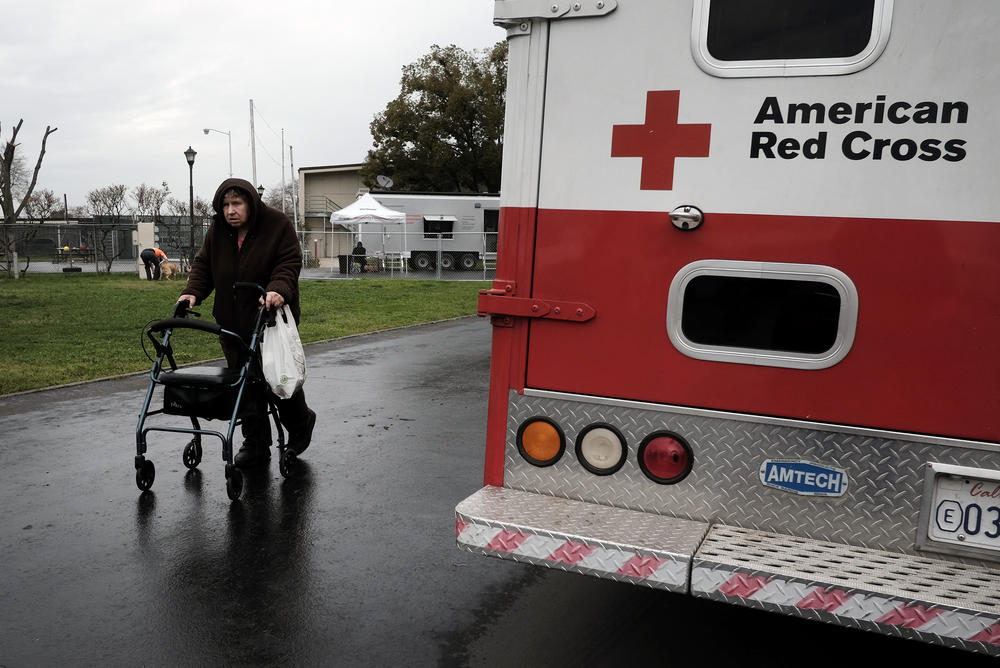 An evacuee walks past an American Red Cross vehicle at an evacuation center in Chico, Calif., on Feb. 15, 2017. Flooding had damaged the nearby Oroville Dam and there was danger it might break. Around 188,000 people were evacuated, but the dam held.