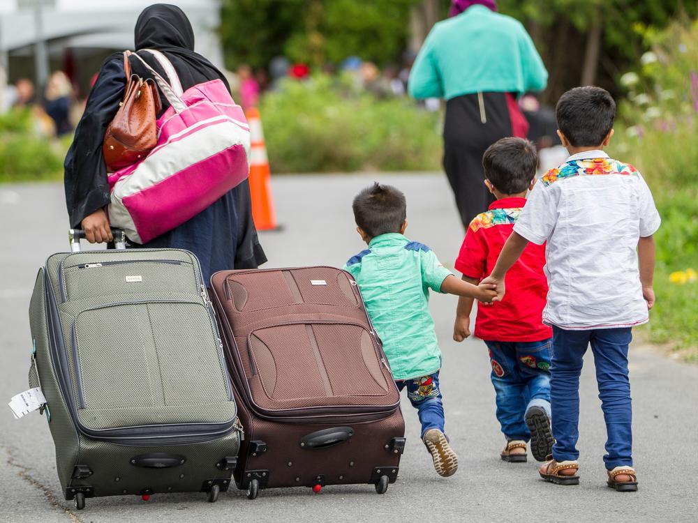 Asylum-seekers walk along Roxham Road near Champlain, N.Y., in August 2017, a popular illegal border crossing into Canada, away from official ports of entry.