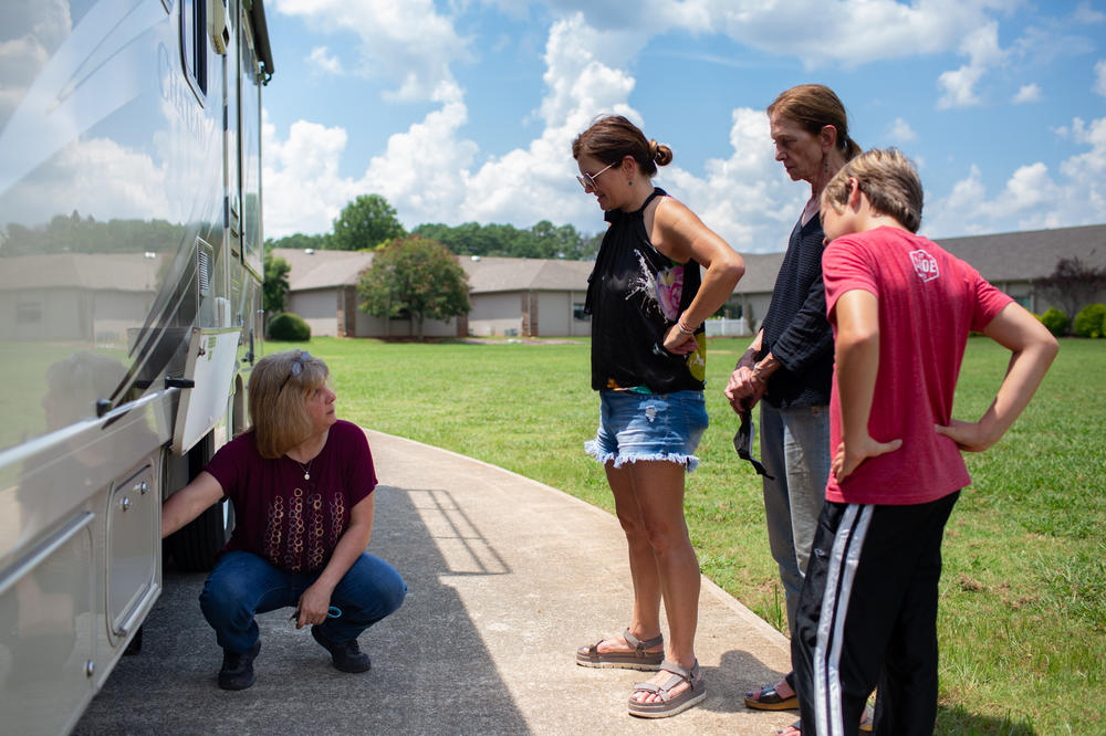 RV owner Cheryl Huettel shows the Holditch family the power and water hookups they will use in campgrounds along their way to Cape Cod. From left: Huettel, Amy Holditch, Sandra Gillis, and Duncan Holditch.