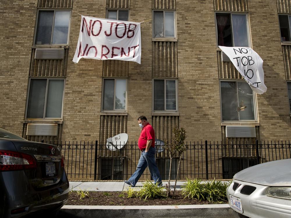 Signs hang from the windows of a Washington, D.C.,  apartment in May. Housing advocates and landlords say millions of out-of-work Americans won't be able to pay their rent if Congress doesn't extend or replace federal unemployment payments.