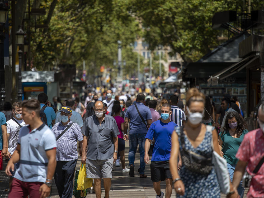 People walk along the Ramblas last week in Barcelona, Spain. The country has seen cases of the coronavirus spike in recent weeks.