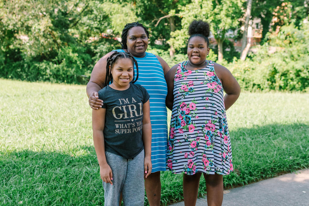 Tranese (left), Harriet and Talayla Feggins stand outside their home in west Atlanta. Talayla, 13, relies on a machine to help with her asthma.