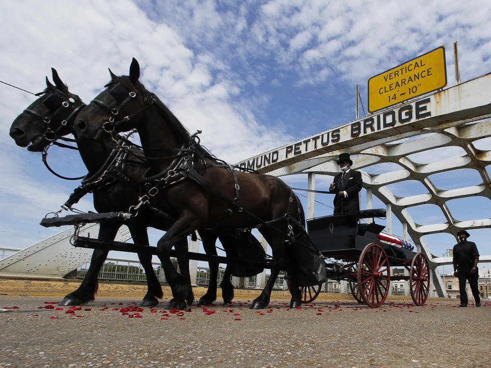 Lewis' casket crosses the Edmund Pettus Bridge via horse-drawn carriage during a ceremony Sunday in Selma, Ala.