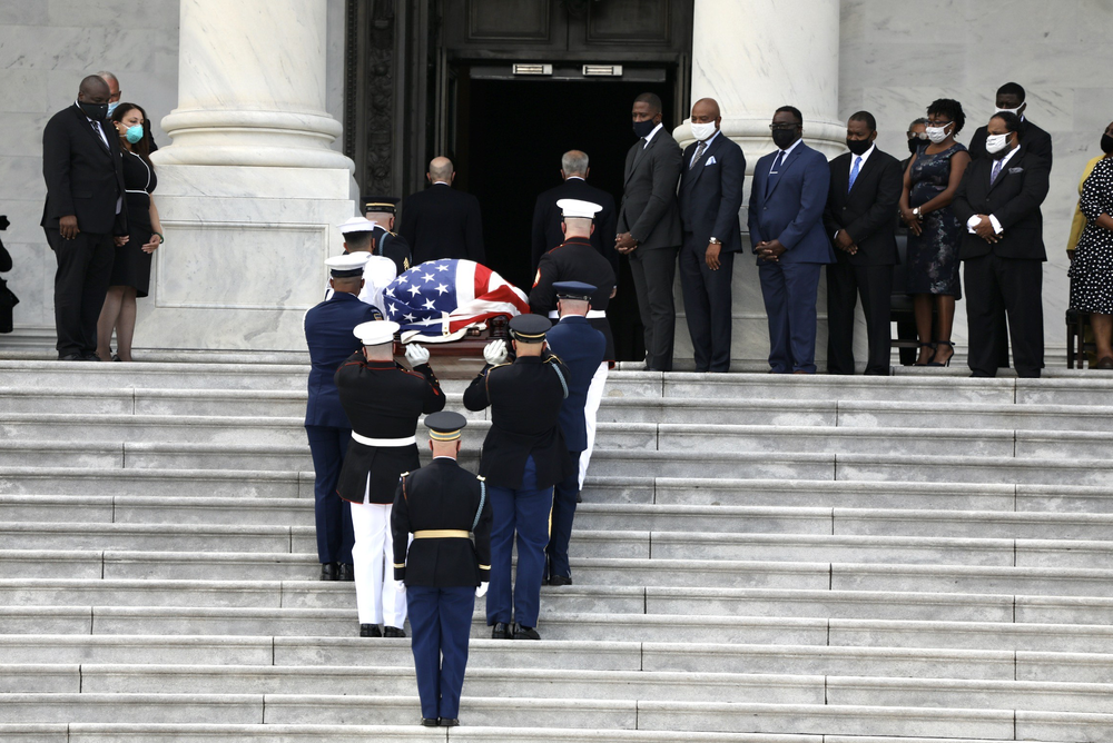 Family members watch as the American flag-draped casket of the late Rep. John Lewis, D-Ga., is carried by a joint services military honor guard outside the U.S. Capitol before a ceremony Monday in Washington, D.C.