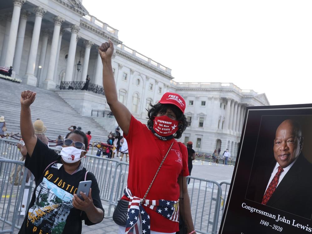 Members of the public wait in line to pay their respects to the flag-draped casket bearing the remains of Rep. John Lewis (D-GA) at the top of the East Front Steps of the U.S. Capitol.