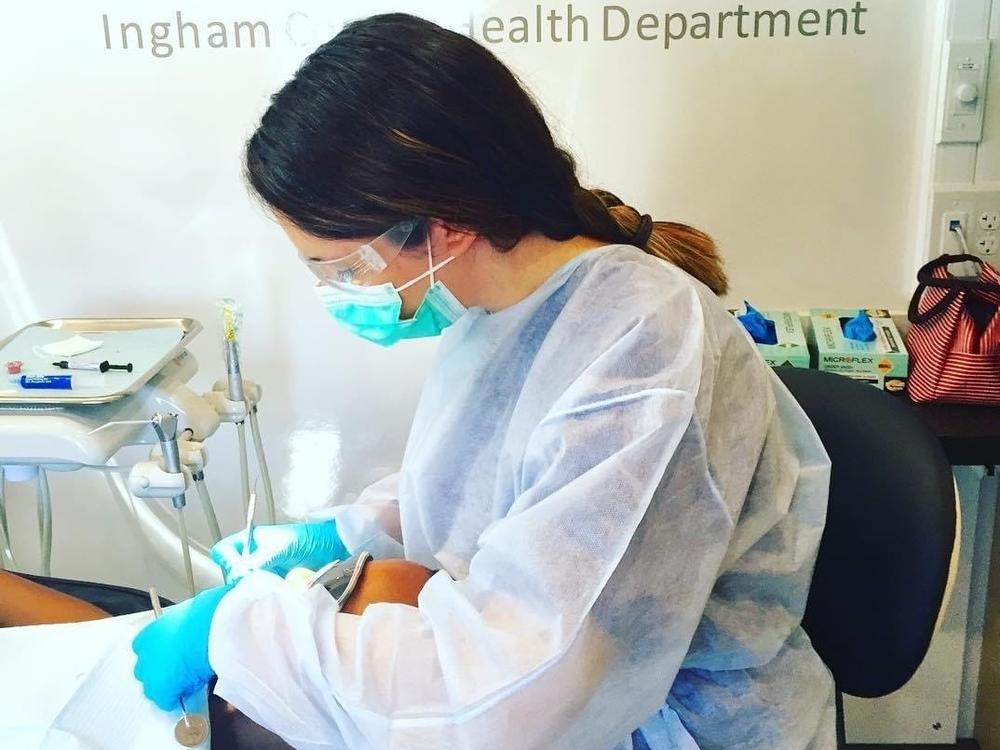 Dental hygienist Alexis Bailey was initially nervous about returning to work but says she quickly grew comfortable with the new protective measures, including a face shield (not shown).