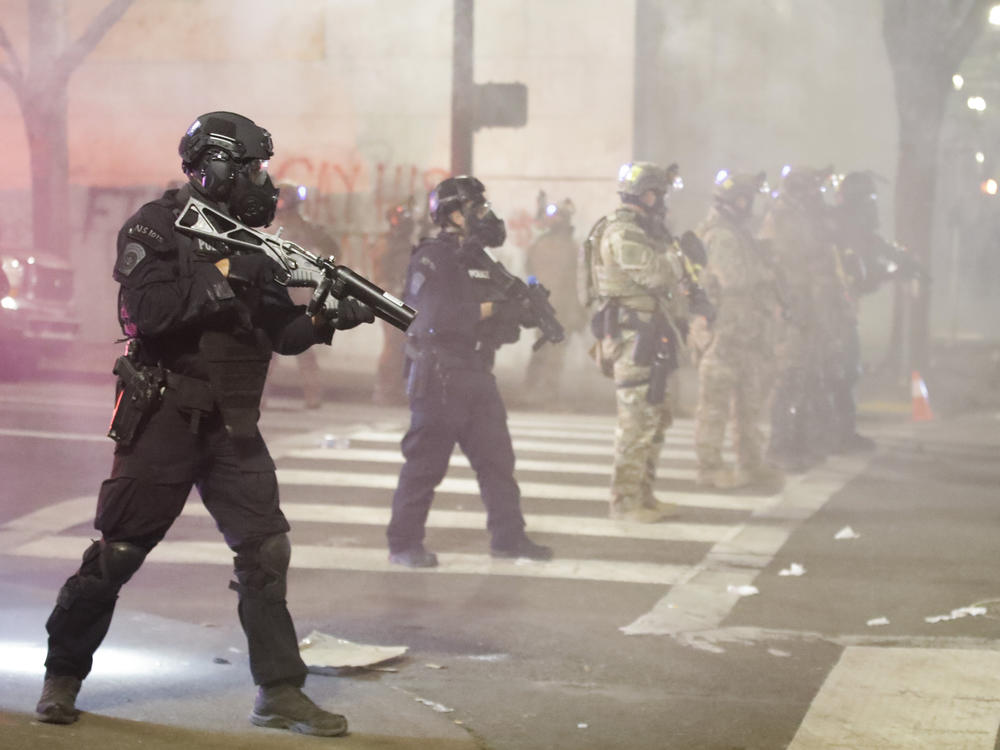 Federal officers deploy tear gas and crowd control munitions at demonstrators during a Black Lives Matter protest Tuesday at the Mark O. Hatfield U.S. Courthouse in Portland, Ore.