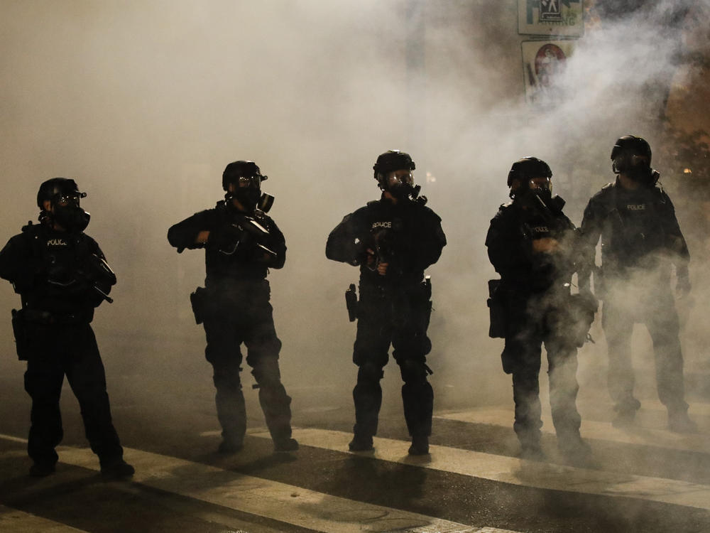 Federal officers are surrounded by smoke as they push back demonstrators during a Black Lives Matter protest at the Mark O. Hatfield United States Courthouse on Wednesday in Portland, Ore.