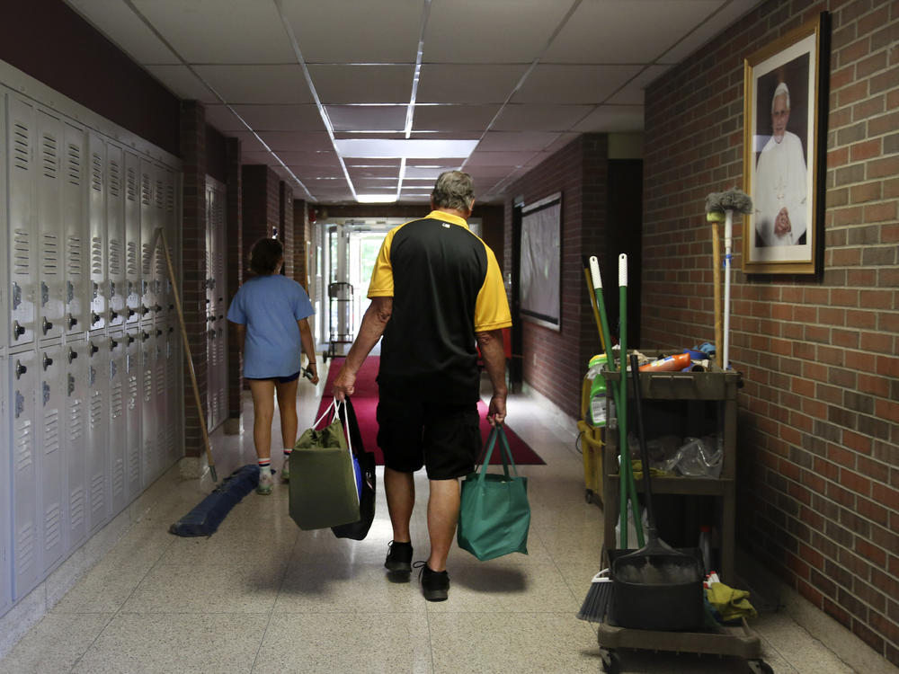 Cesa Pusateri, 12, and her grandfather, Timothy Waxenfelter, principal of Quigley Catholic High School, leave with his collection of speech and debate books after the closure of the school in Baden, Pa., on June 8, 2020. According to the National Catholic Educational Association, at least 100 schools have announced in recent weeks that they won't reopen this fall.