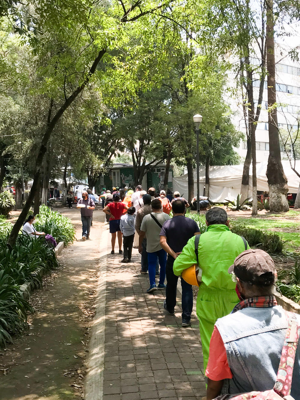 People line up for food from a soup kitchen in Mexico City. The city's welfare agency has scrambled to deal with growing demand as the pandemic deepens Mexico's recession.