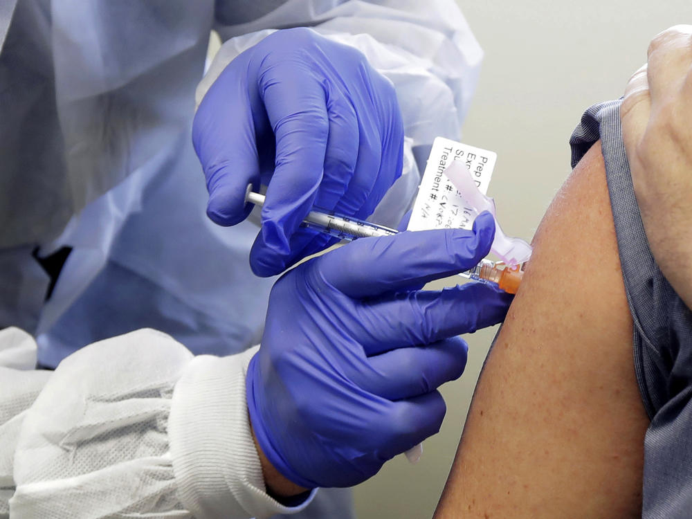 A patient in a first-stage study of a potential vaccine for COVID-19 receives a shot in March at the Kaiser Permanente Washington Health Research Institute in Seattle.