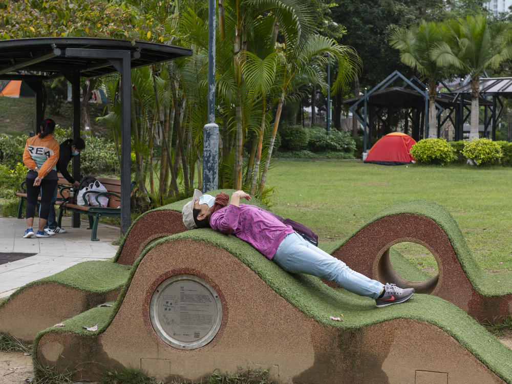 New rules in Hong Kong require everyone to wear a mask in all outdoor places or face a $650 fine. Above: A masked woman stretches out a public park. Also: The maximum number of people allowed at a public gathering is ... 2.