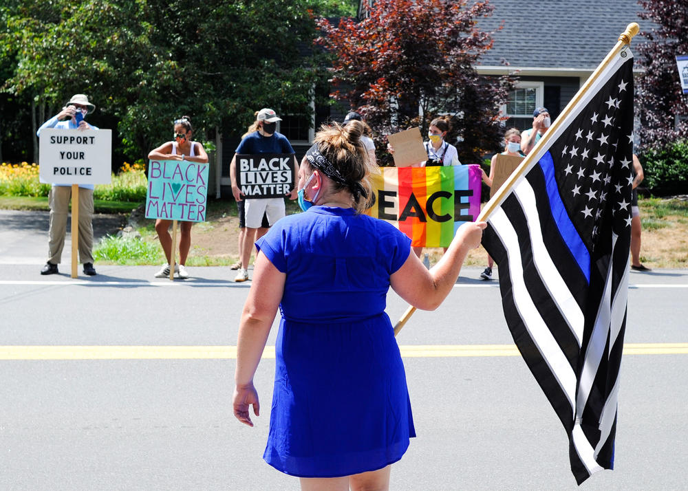A rally between who are for and against thin blue line flags in Hingham, Mass., on Tuesday. Some see the flag as a proud tribute to police officers, while others denounce it as a racist symbol.