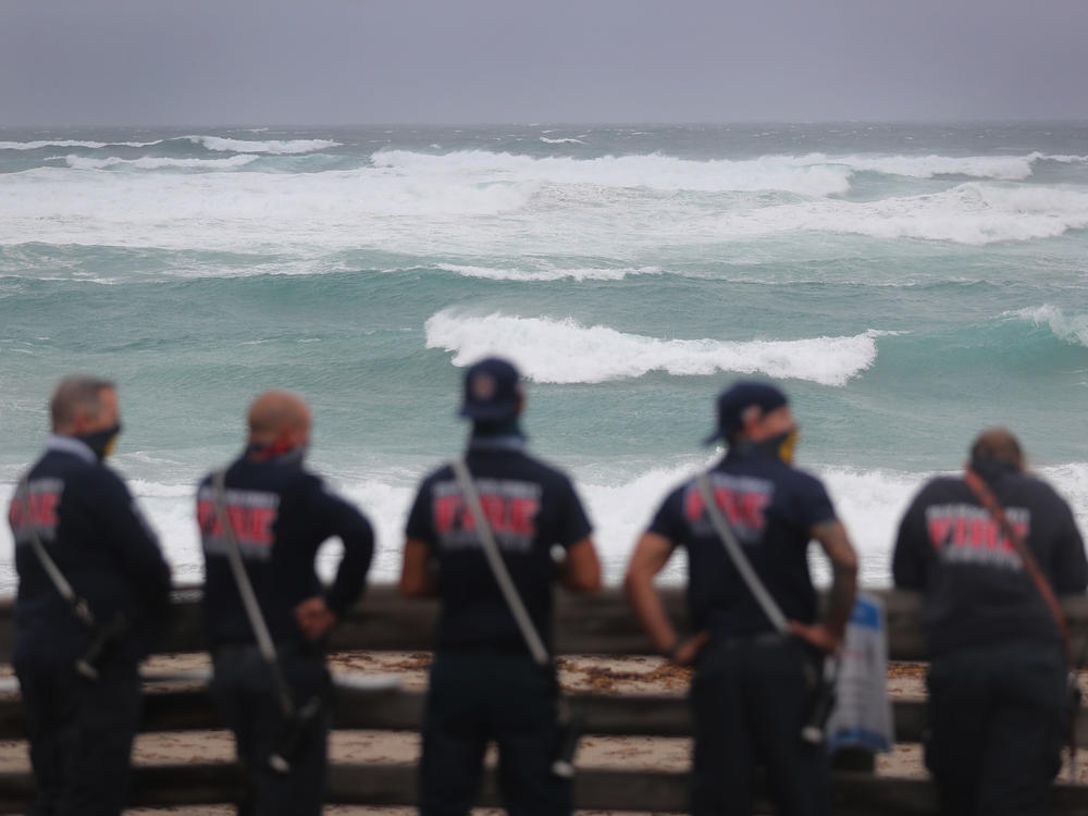 Palm Beach County Fire Rescue check out the ocean as waves crash ashore from Tropical Storm Isaias as it passes through the area on August 2, 2020 in Juno Beach, Fla.
