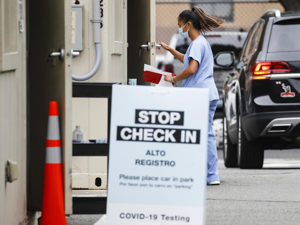 Six states have an agreement to acquire fast-result antigen tests for the coronavirus. Here, a medical worker collects a sample after a patient self-administers a nasal swab test.