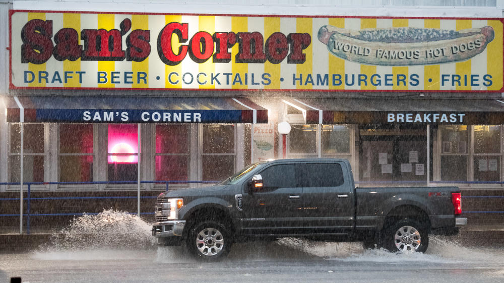 A truck passes the Sam's Corner restaurant in Garden City, S.C., on Monday during heavy rains from Hurricane Isaias. Now a tropical storm, Isaias is moving north-northwest along the U.S. Eastern Seaboard.