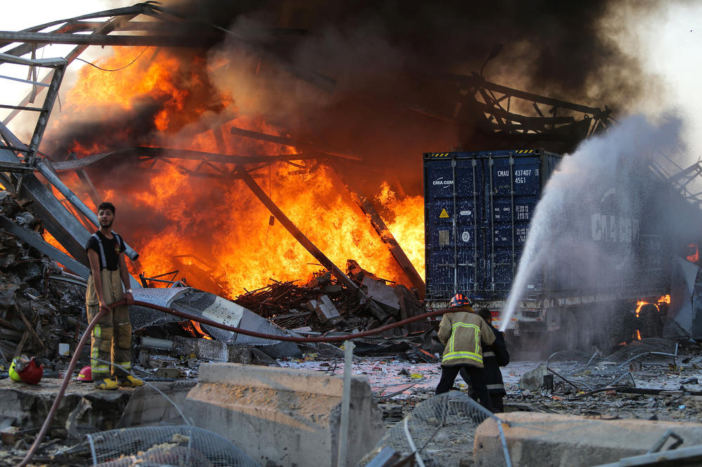 Firefighters douse a fire at Beirut's port. Hours after the blast, numerous Beirut hospitals are reportedly overwhelmed.