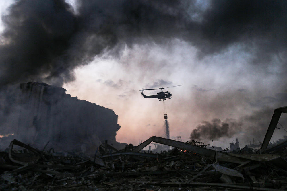 A helicopter puts out a fire at the port in Beirut. Tuesday's explosion was felt miles away.