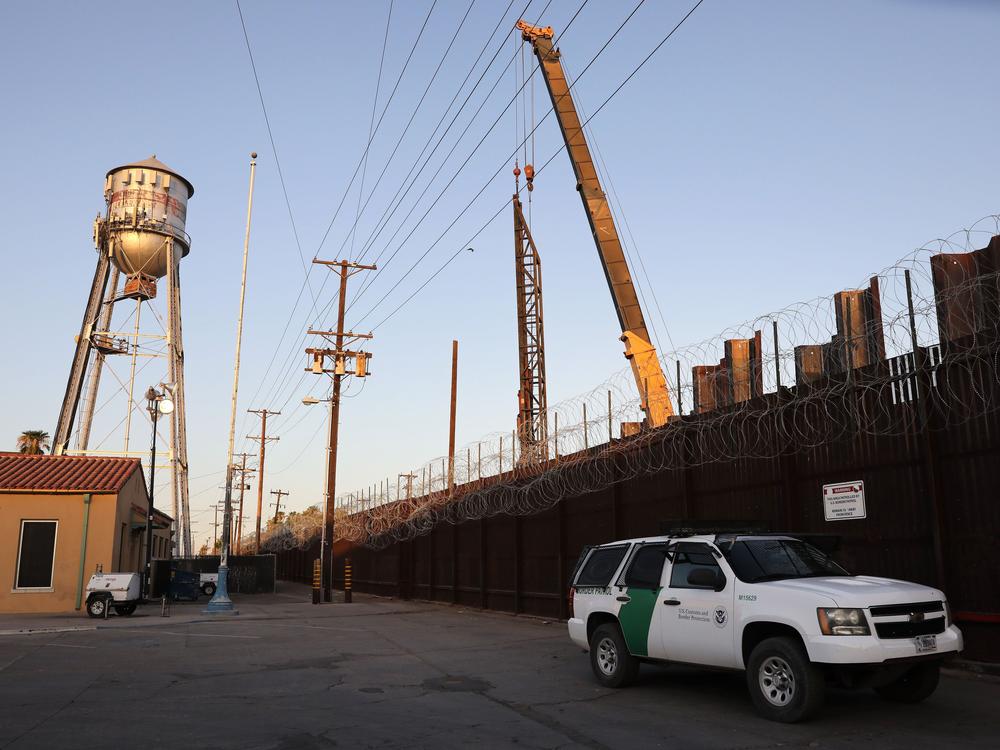 A U.S. Border Patrol vehicle is stationed in front of the U.S.-Mexico border barrier as construction continues in hard-hit Imperial County on July 22, in Calexico, Calif.