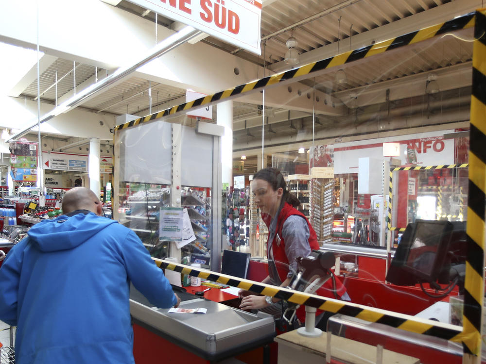 A cashier accepts payment from a customer in Munich in March.