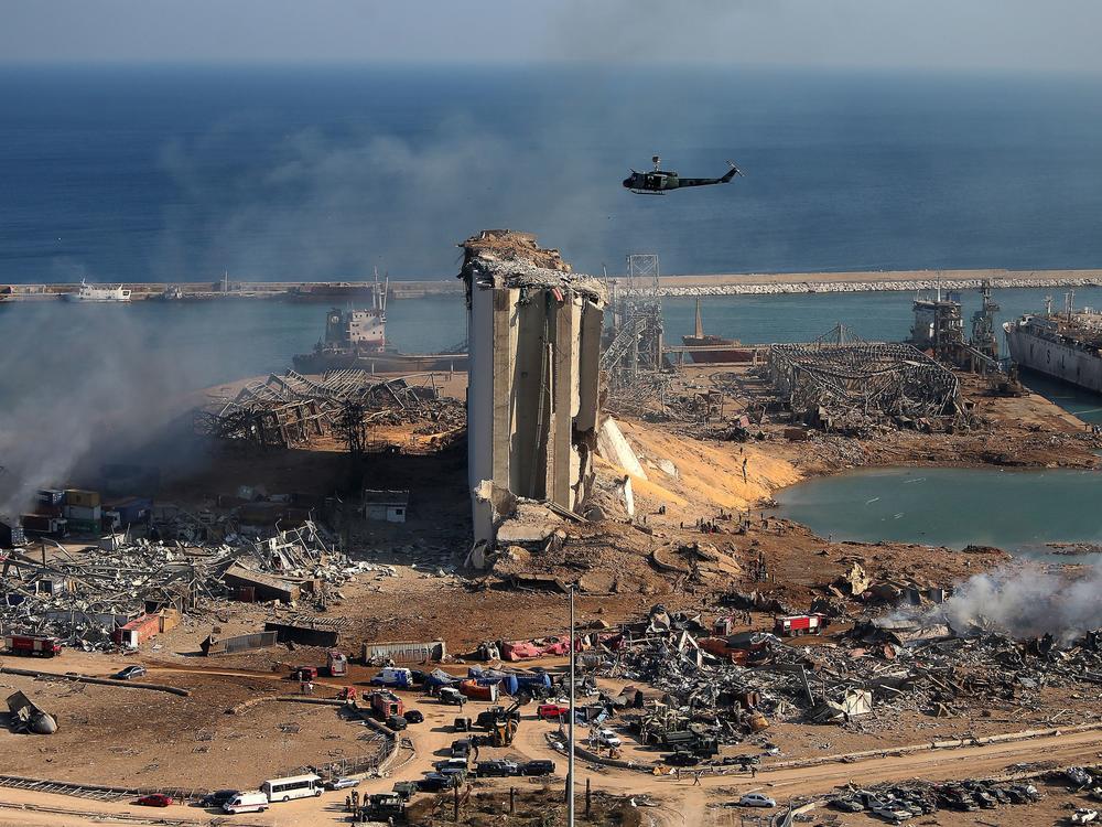 A helicopter hovers over damaged grain silos in Beirut's port on Wednesday, one day after a powerful explosion tore through Lebanon's capital.