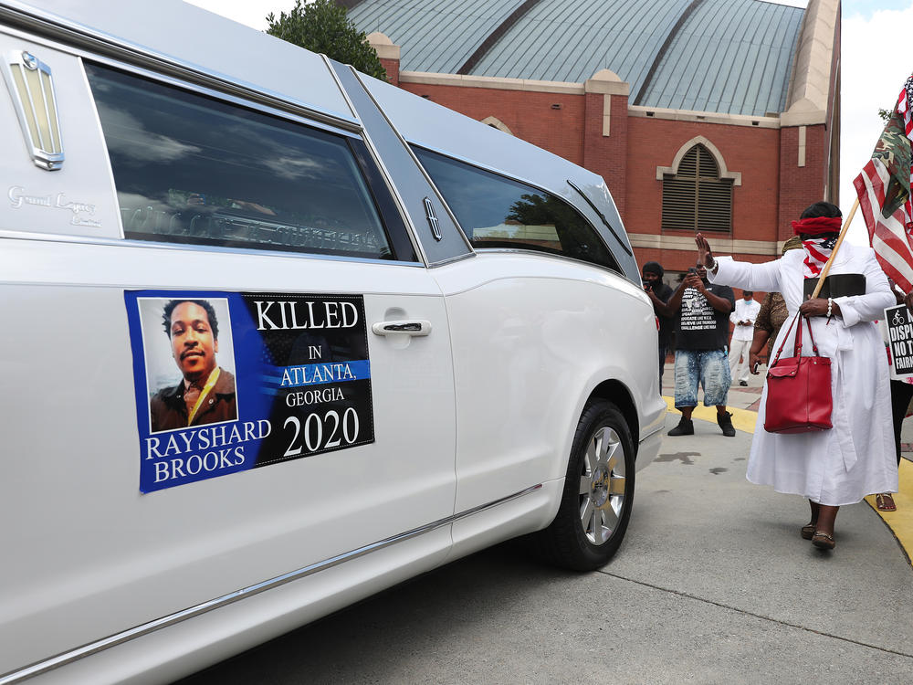 People gather near a hearse carrying Rayshard Brooks' body after his June 23 funeral at Ebenezer Baptist Church in Atlanta.