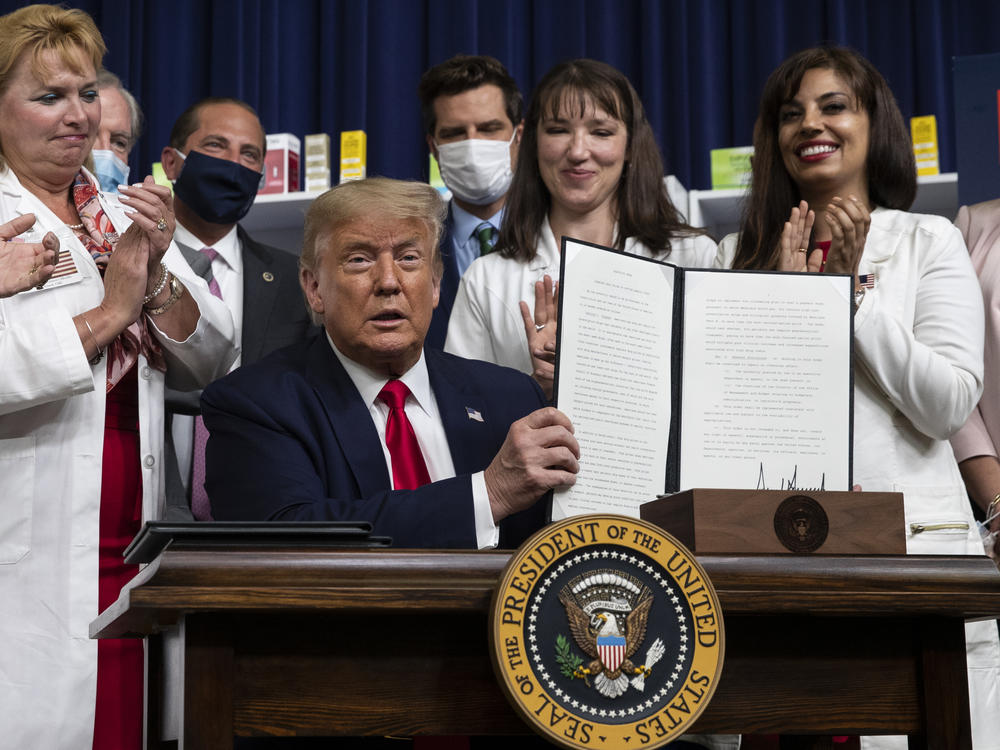 President Trump holds up a signed executive order on lowering drug prices on July 24.