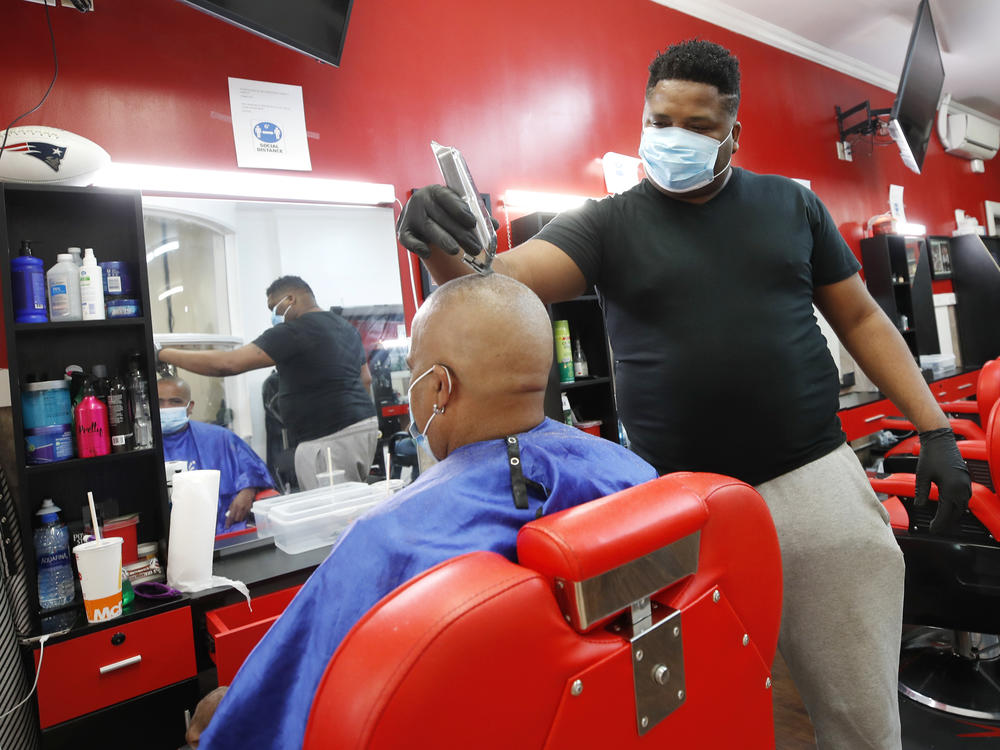 Wilkin Soto works on a customer at the Castillo Barbershop, in Lawrence, Mass., on June 5. The pace of hiring has slowed from June, when employers added a record 4.8 million jobs.