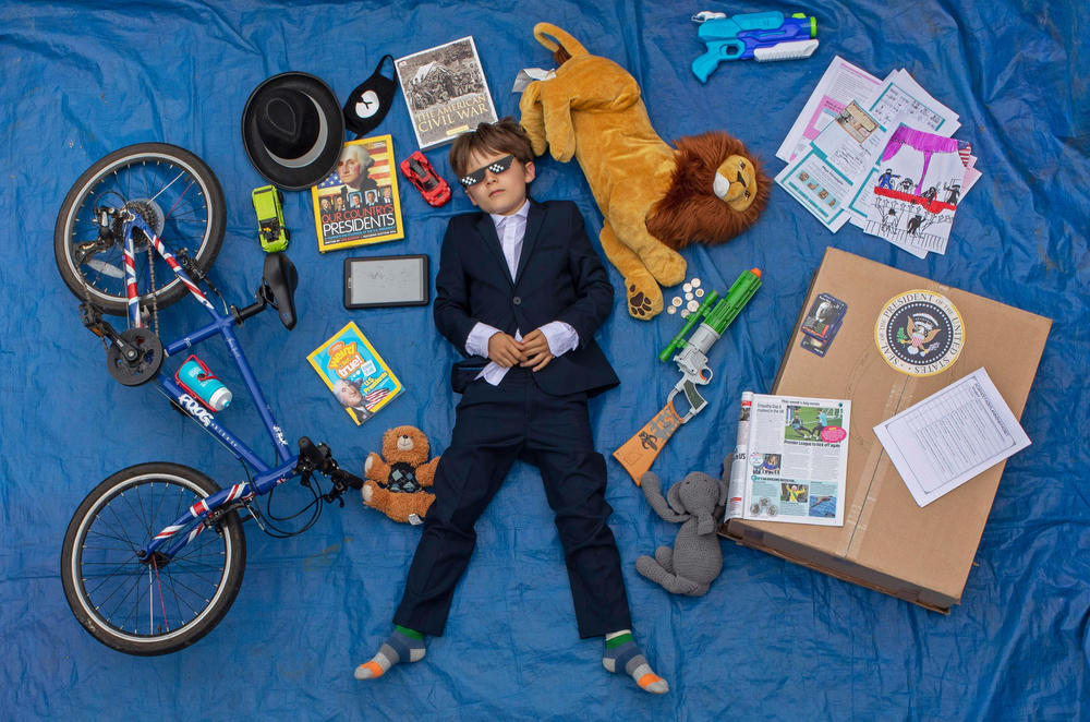 Ben, 10, lays next to his favorite objects, toys and books as part of a homeschooling assignment to create a time capsule to remind them of this time.