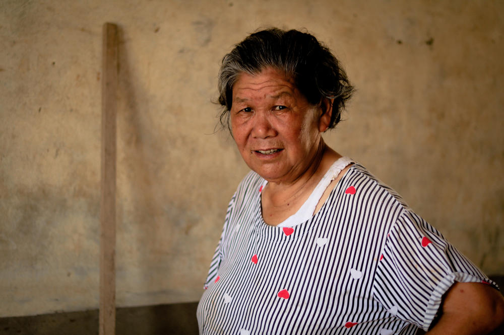 Tang Anfeng, a Hekou native, explains how the local government releases excessive rainwater behind dams to relieve pressure. 