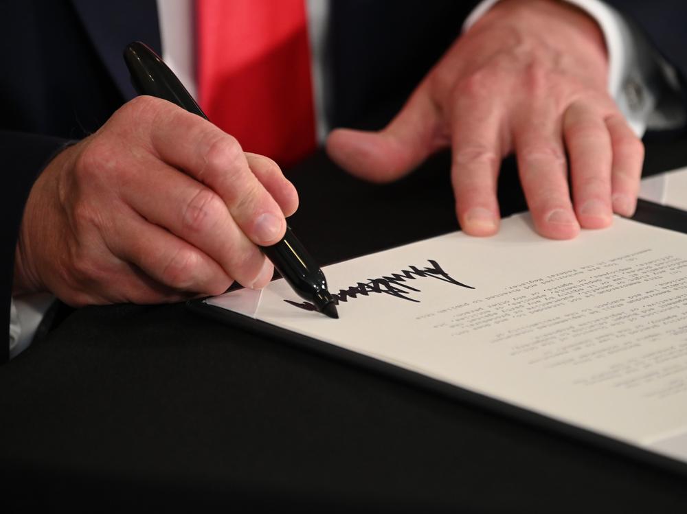 President Trump signs executive actions regarding coronavirus economic relief during a news conference in Bedminster, N.J., on Saturday. A number of lawmakers are criticizing the measures' substance and constitutionality.