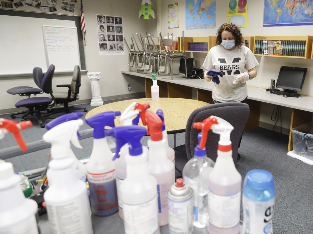 Charo Woodcock cleans a classroom at McClelland Elementary School in June in Indianapolis. Students across Indiana are already back in school in a mix of in-person and online instruction.