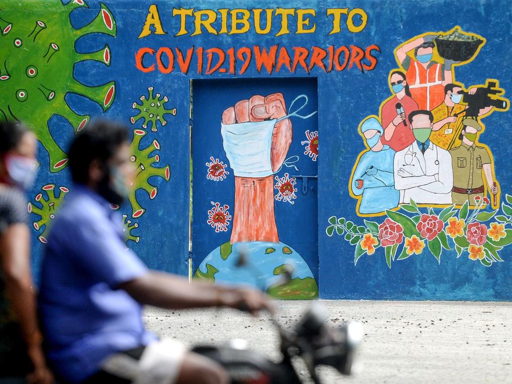 A mural in Chennai, India, celebrates workers on the front lines against the coronavirus pandemic. The global case count crossed the 20 million threshold on Monday, with the U.S., Brazil and India in the lead.