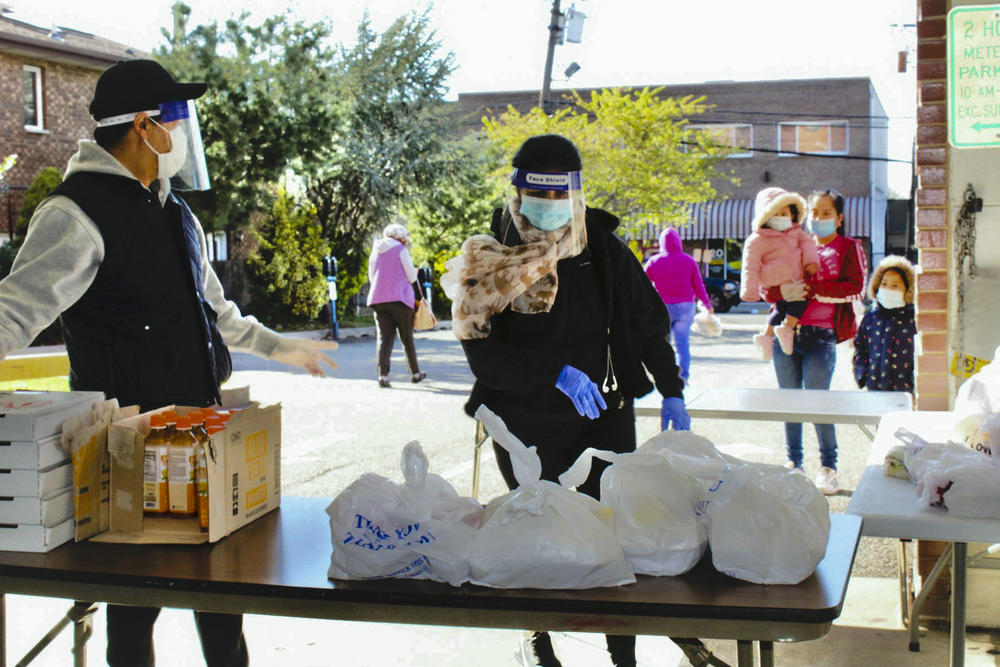 Volunteers Juan Ramirez and Neris Papoter get ready to serve meals to families for Our Community Dinner Table. Ramirez and Papoter, who are married, have donated over 15,000 water bottles and have volunteered with the group almost every single day since it began operating.