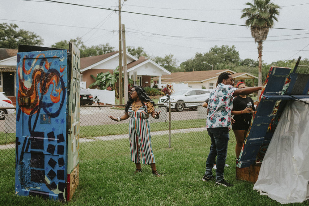 Artists Shawana Brooks and her husband, Roosevelt Watson III, talk to visitors at the 6 Ft. Away Gallery, an art space they created in their yard.