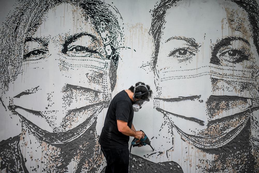 Street artist Alexandre Manuel Dias Farto finds art in today's viral warriors. Above, a wall of São João Hospital in Porto, Portugal, in June 2020.